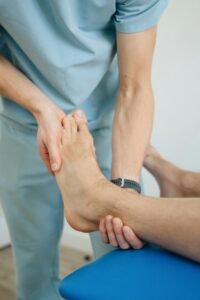 Close-up of a physiotherapist performing foot therapy for patient recovery in a clinic.
